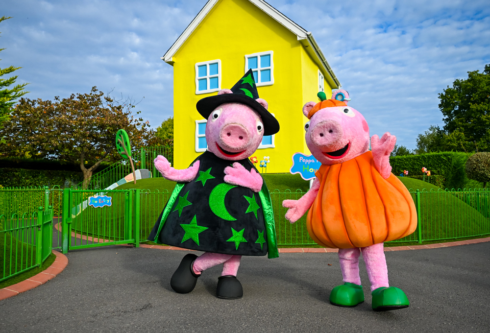 Peppa Pig and George dressed in Halloween costumes in front of Peppa’s House in Peppa Pig World