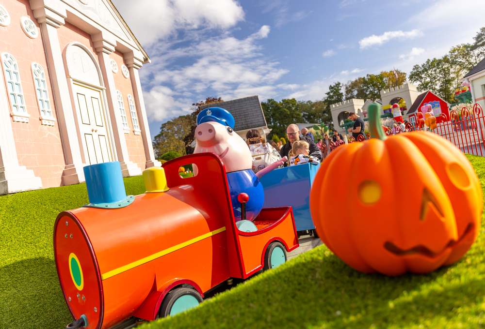 Peppa Pig World at Halloween with Grandpa Pig's Little Train passing a pumpkin decoration
