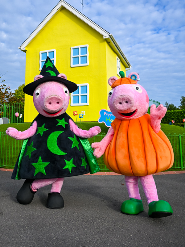 Peppa Pig World Halloween image featuring Peppa Pig and George Pig dressed in witch and pumpkin costumes