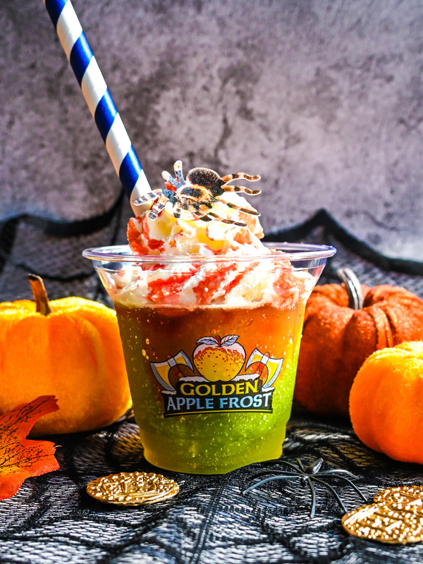 Paultons Park Halloween Golden Apple Frost drink topped with whipped cream and a spooky spider decoration